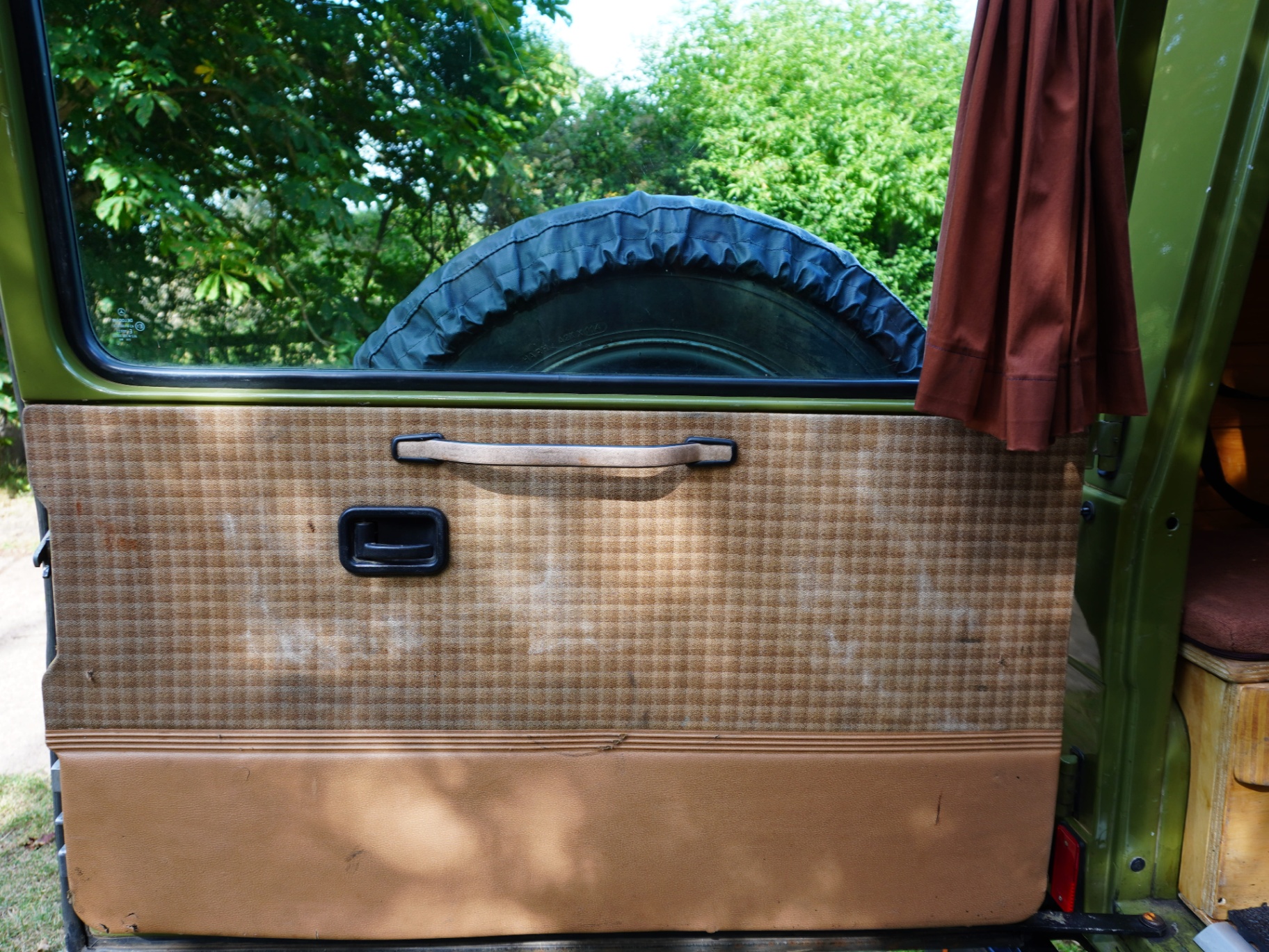 Rear door card in tan houndstooth with spare-wheel view
